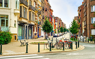 residential/commercial street in Brussels with buildings, parked cars and parked bicycles